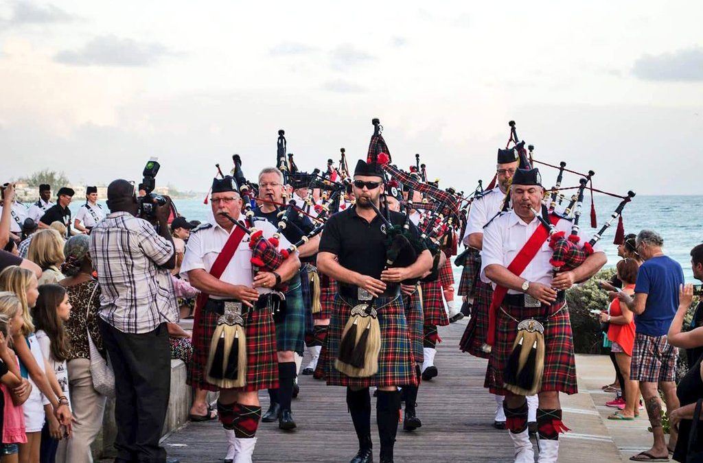 Group of men playing bagpipes on a Barbados boardwalk