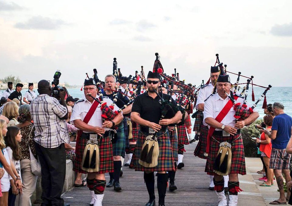 Group of men playing bagpipes on a Barbados boardwalk