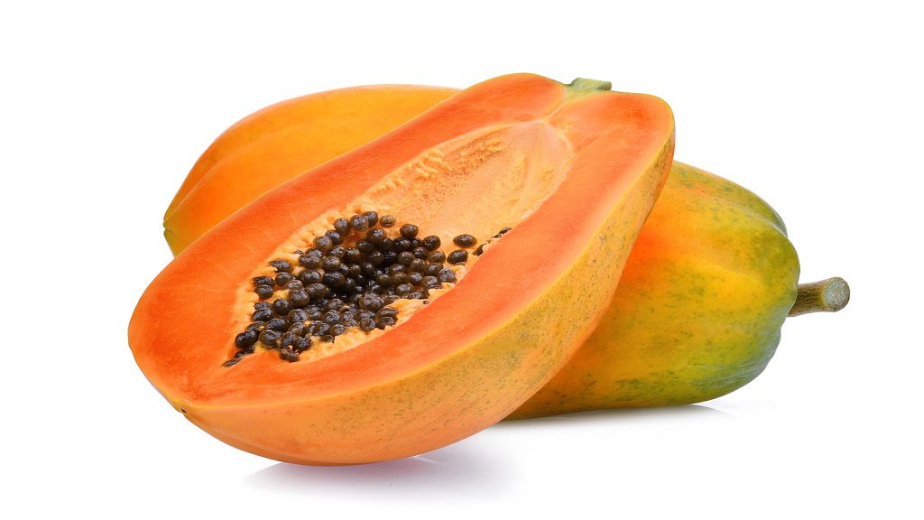 Whole and half of ripe Papaya fruit with seeds, isolated on white background.